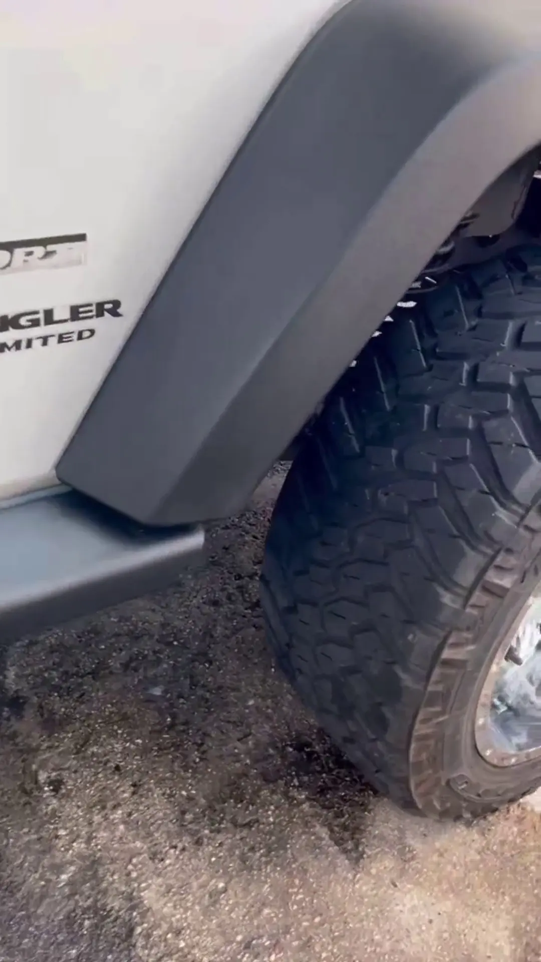 Restored black fender flare on a white Jeep Wrangler